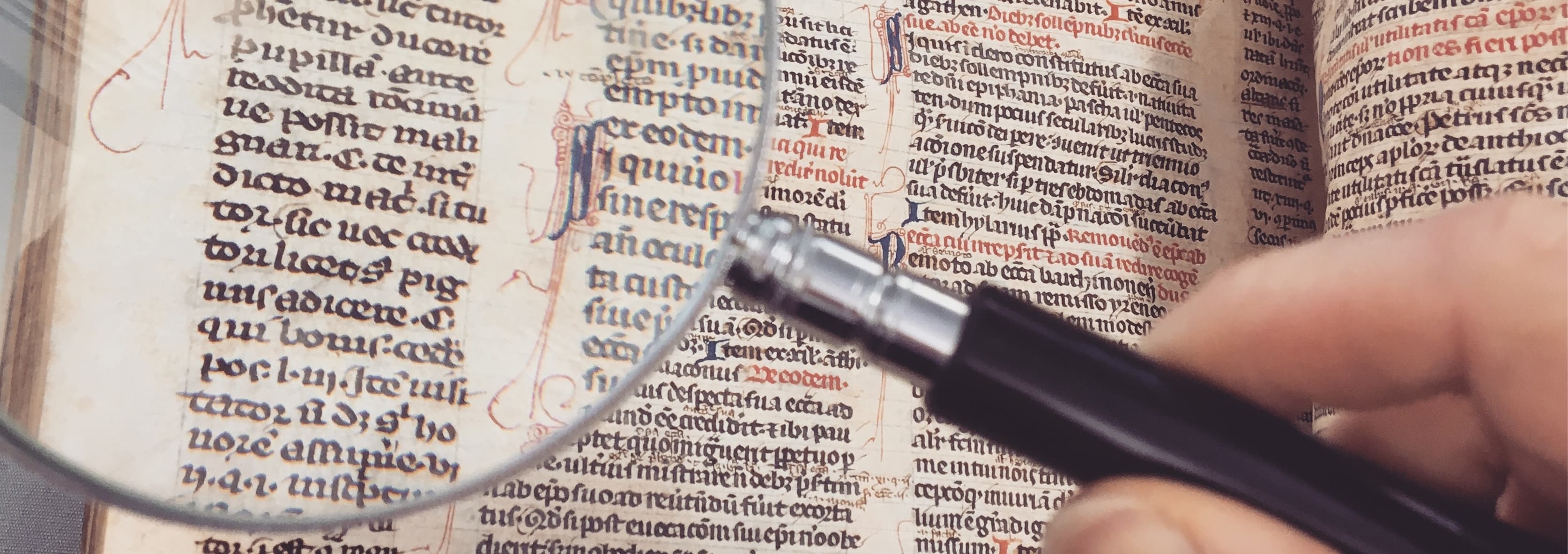 Photograph of agnifying glass over ancient text